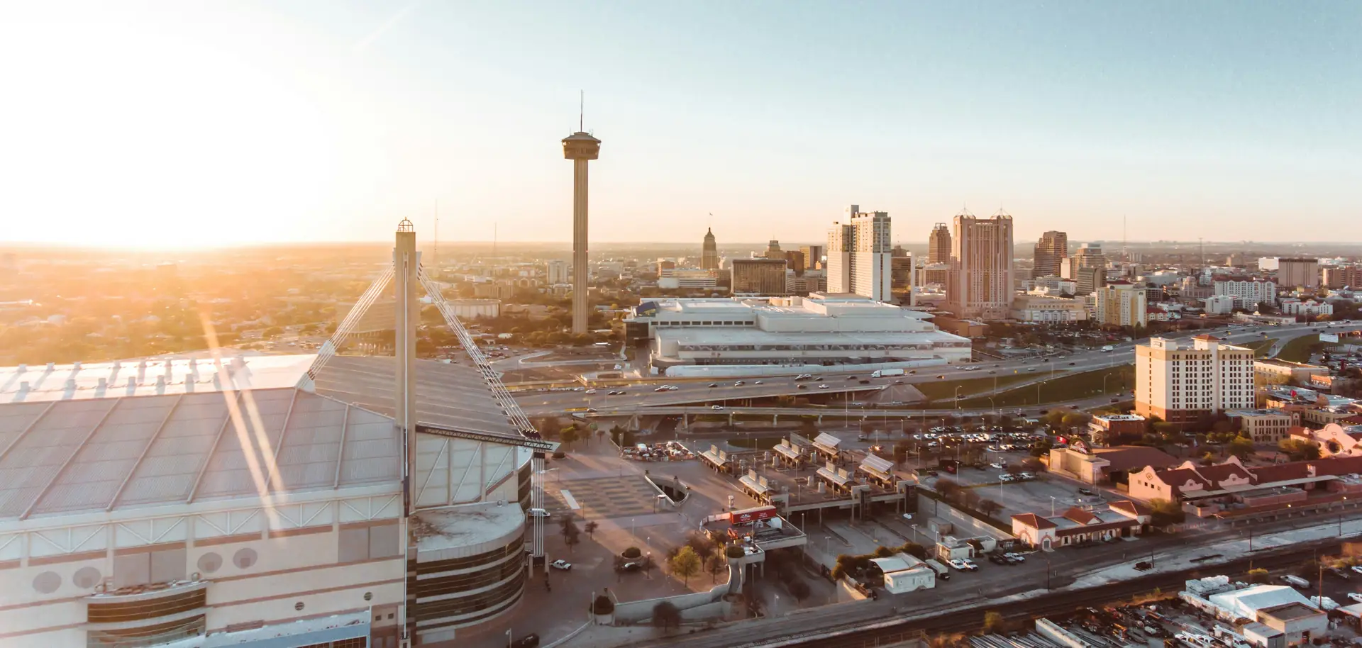 San Antonio skyline at sunset with the Tower of the Americas rising above downtown